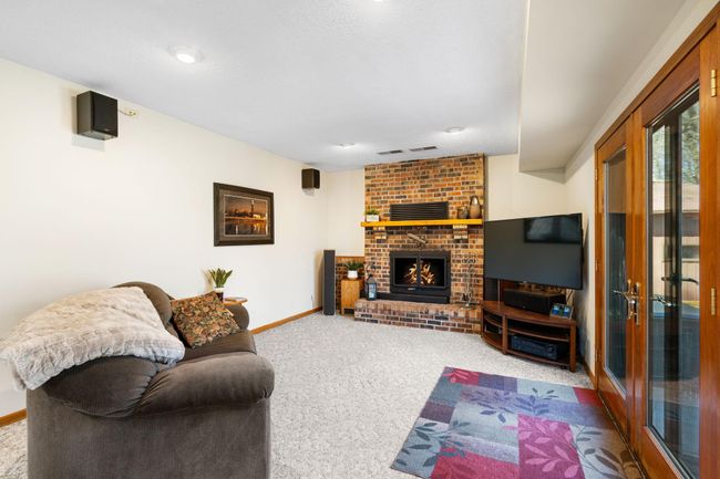 The warm and cozy family room features a wood burning fireplace. This powerful tool keeps the house warm with light effort and provides maximum ambience. | Image 19