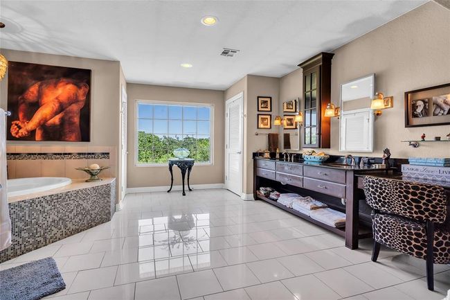 Bathroom with double vanity, a garden tub, baseboards, recessed lighting, and tile patterned flooring | Image 23