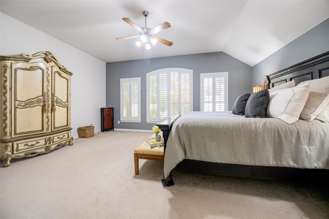 primary bedroom featuring lofted ceiling, ceiling fan, view of the yard, and lots of space. | Image 13