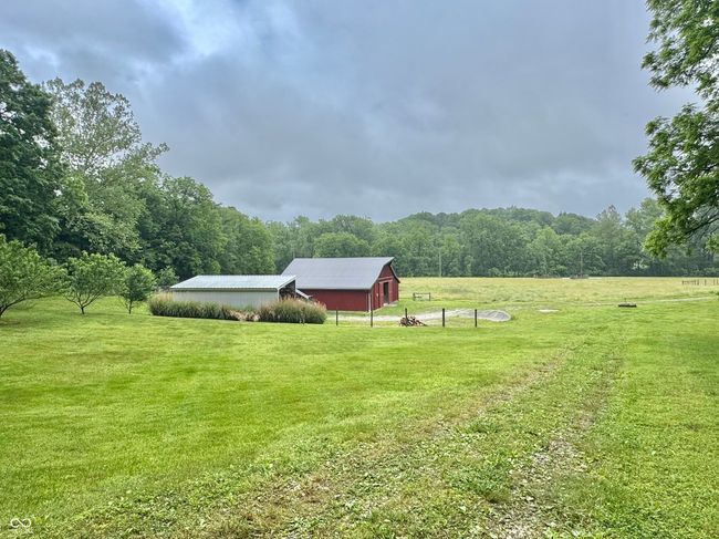 view of grassy yard with a view of rural / pastoral area, a forest view, and an outdoor structure | Image 22