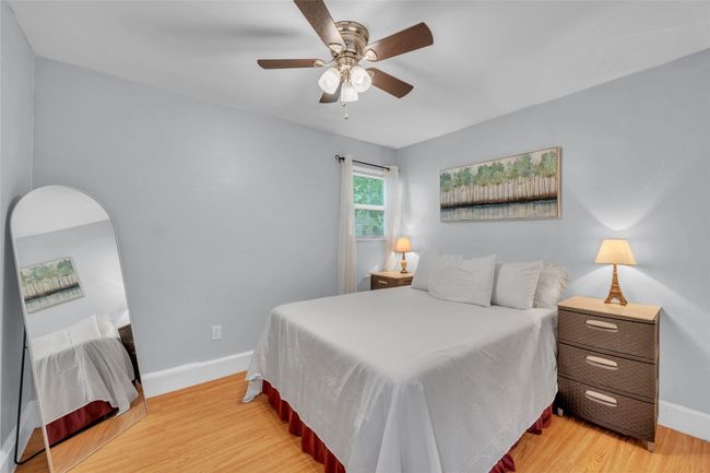 Bedroom featuring light wood-style floors, baseboards, and a ceiling fan | Image 11