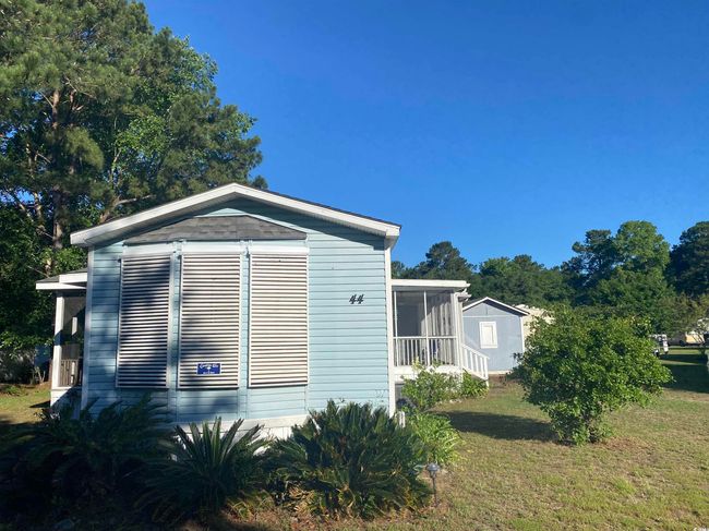 View of side of home with a storage unit, a lawn, and a sunroom | Image 7