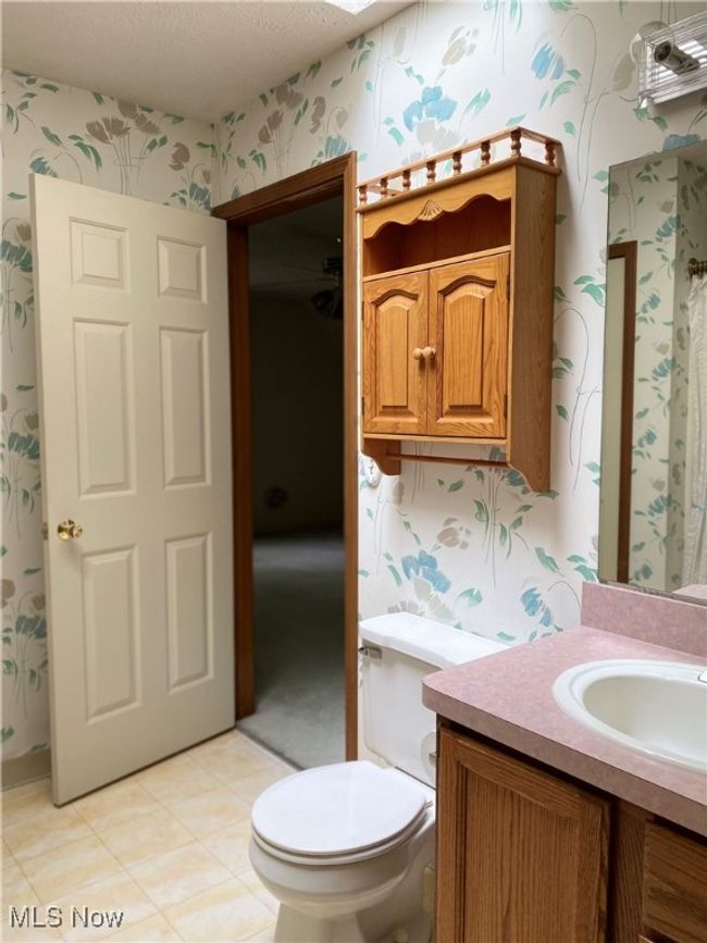 Bathroom featuring wallpapered walls, vanity, a textured ceiling, and toilet | Image 10