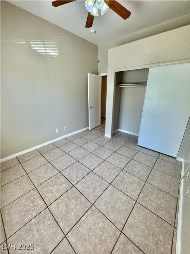 Unfurnished bedroom featuring a closet, baseboards, ceiling fan, and light tile patterned floors | Image 14