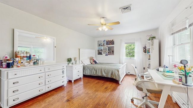 Huge 2nd Floor Bedroom with light stained hardwood floors, baseboard heating, ceiling fan, large closet and an office area. | Image 27