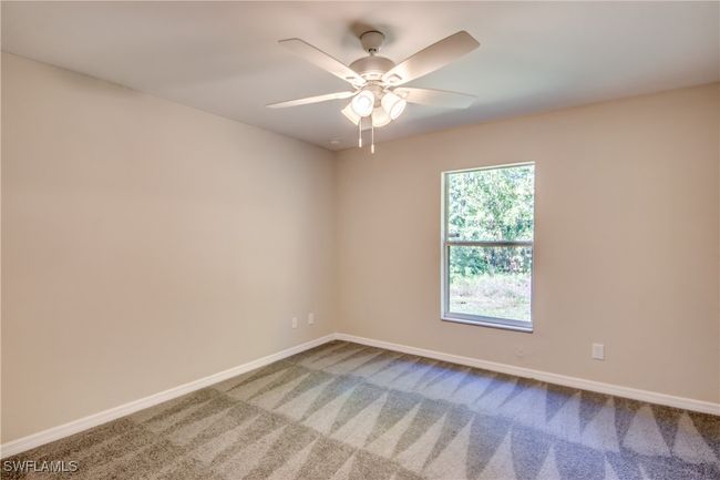 Carpeted empty room with a ceiling fan and baseboards | Image 29