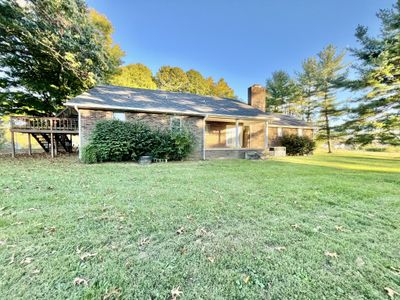 Back of house overlooking the large fenced backyard with tall mature trees | Image 3