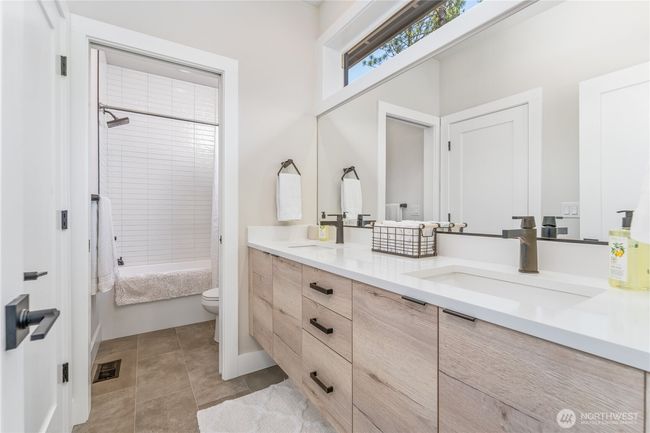 The luxurious bathroom offers elegant design and convenient access from two bedrooms, featuring high-end finishes and stylish fixtures that combine comfort with sophistication for guests and residents | Image 25