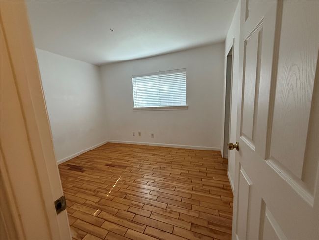 Unfurnished bedroom with light wood-type flooring and baseboards | Image 16