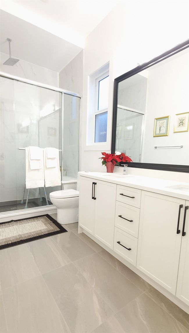 Full bath featuring double vanity, a sink, a stall shower, and toilet | Image 28