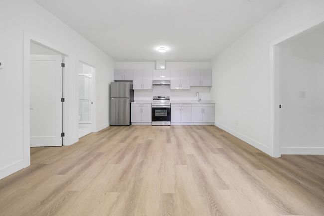 Kitchen with appliances with stainless steel finishes, light countertops, baseboards, and light wood finished floors | Image 28