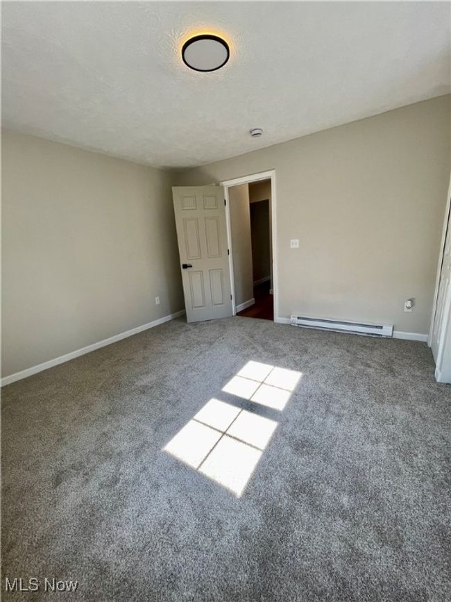 Unfurnished room with a baseboard heating unit and carpet flooring | Image 23