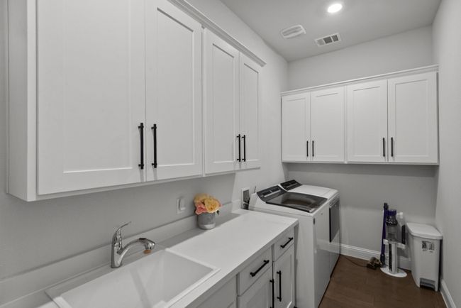 Charming laundry room with a plethora of custom cabinets | Image 31