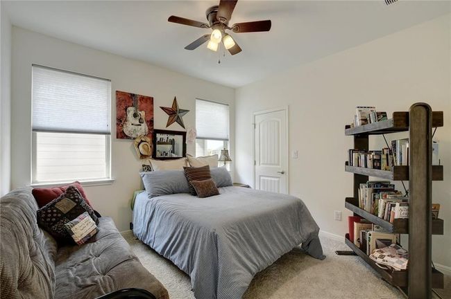 Bedroom featuring light colored carpet, ceiling fan, and baseboards | Image 23