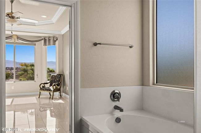 Bathroom with crown molding, a bath, a ceiling fan, tile patterned floors, and baseboards | Image 47