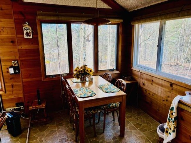 Dining area featuring wood walls and a textured ceiling | Image 10