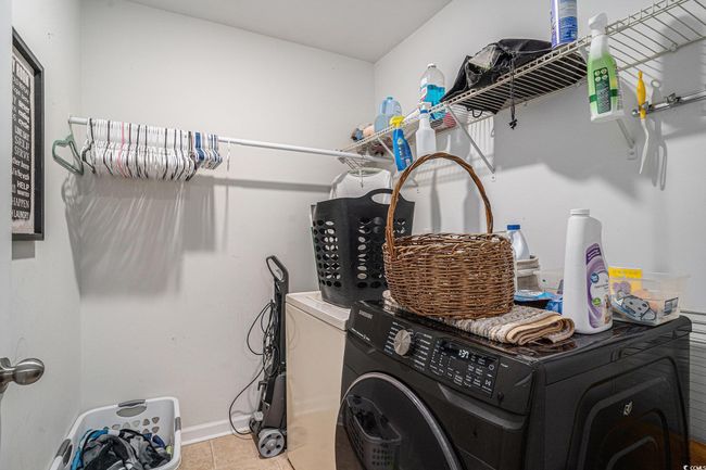 Washroom with washer / clothes dryer, light tile patterned floors, and baseboards | Image 17