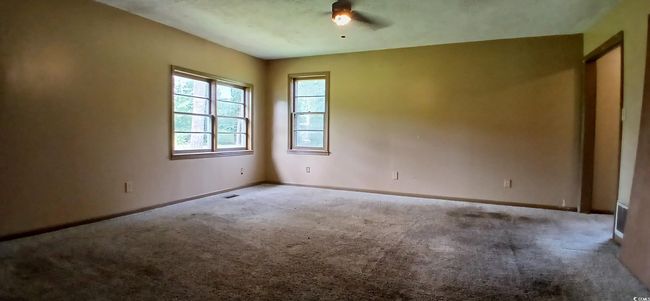 Carpeted spare room featuring baseboards and ceiling fan | Image 23