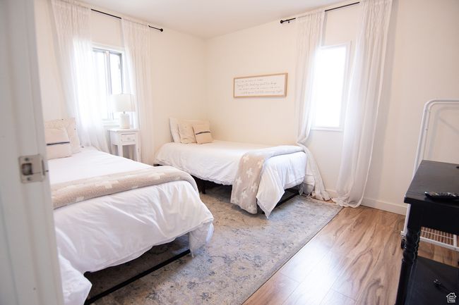 Bedroom with multiple windows, wood finished floors, and baseboards | Image 23