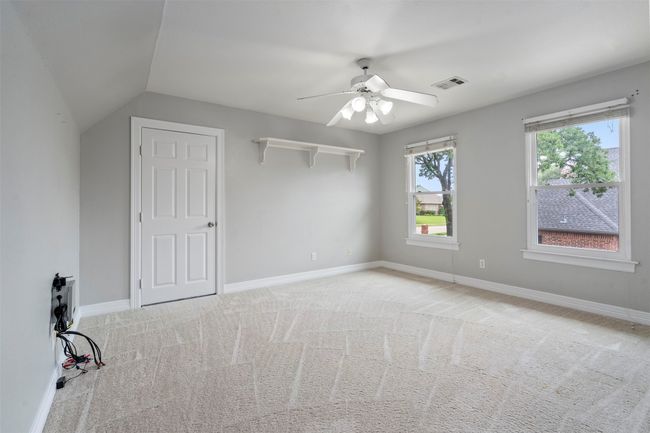 Unfurnished bedroom with light carpet, baseboards, ceiling fan, and lofted ceiling | Image 20