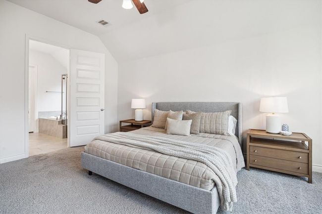 The cozy primary suite features plush, elegant carpeting and a spacious en suite bathroom, creating a private and comfortable retreat. | Image 18