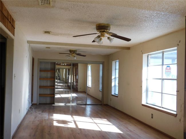 Unfurnished room with ceiling fan, light hardwood / wood-style floors, and a textured ceiling | Image 5