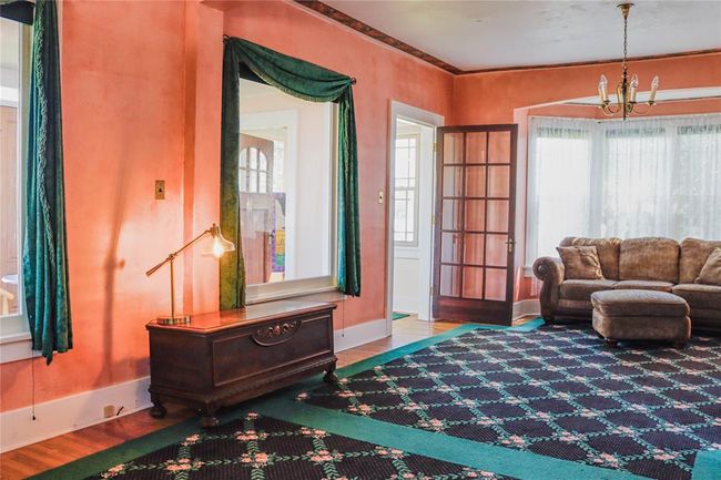 Sitting room with a notable chandelier, wood floors and customized area rugs | Image 12