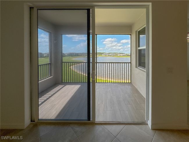 Unfurnished sunroom featuring a water view and baseboards | Image 11