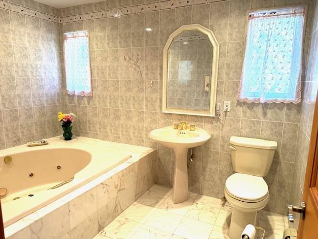 Bathroom featuring toilet, tile walls, and tiled tub | Image 9