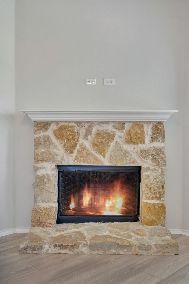 Detailed view of a stone fireplace and wood finished floors | Image 15