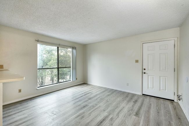 Unfurnished living room with wood finished floors and a textured ceiling | Image 4