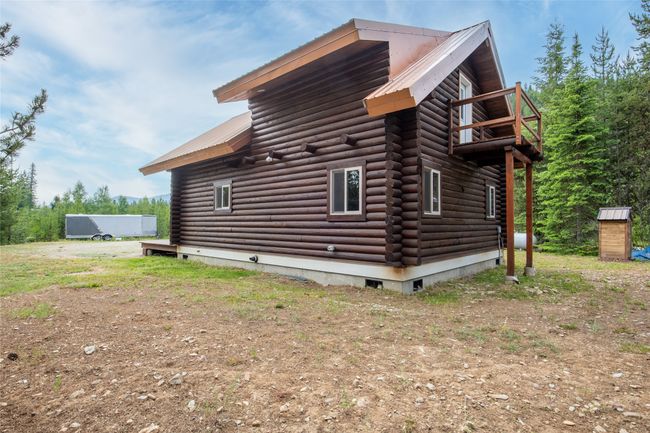 View of property exterior featuring log exterior, a metal roof, a balcony, and crawl space | Image 56