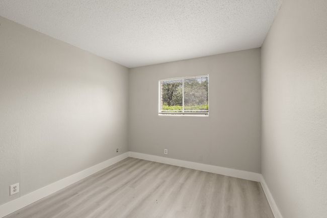 Empty room with light wood-type flooring and a textured ceiling | Image 18