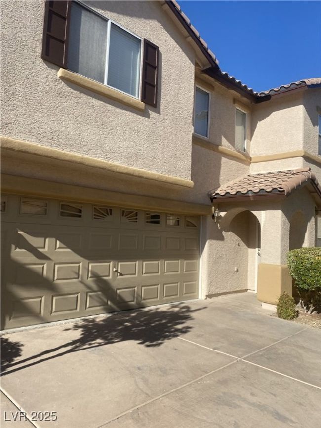 Multi unit property with stucco siding, a tiled roof, concrete driveway, and a garage | Image 23