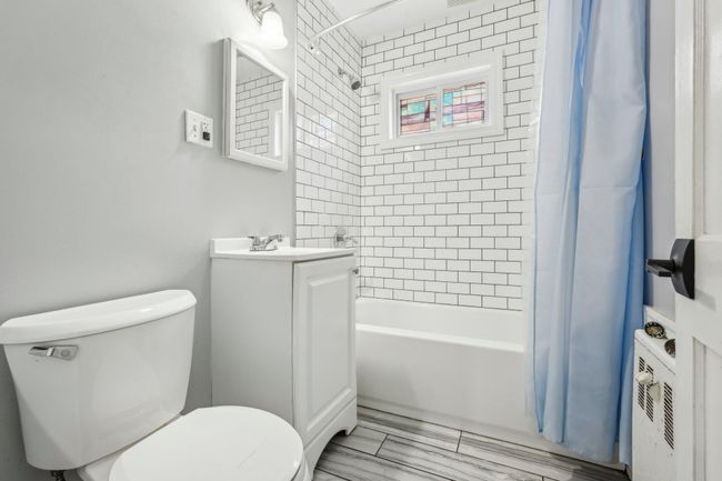 Full bath featuring toilet, shower / bath combo with shower curtain, and vanity | Image 12
