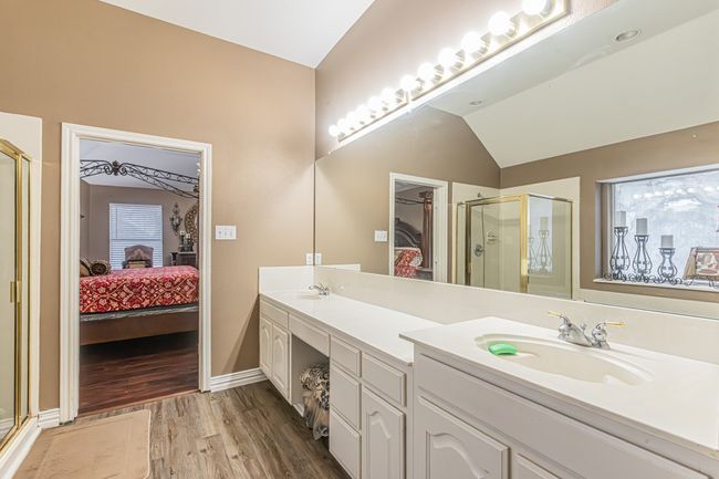 Ensuite bathroom with a stall shower, wood finished floors, double vanity, and lofted ceiling | Image 25