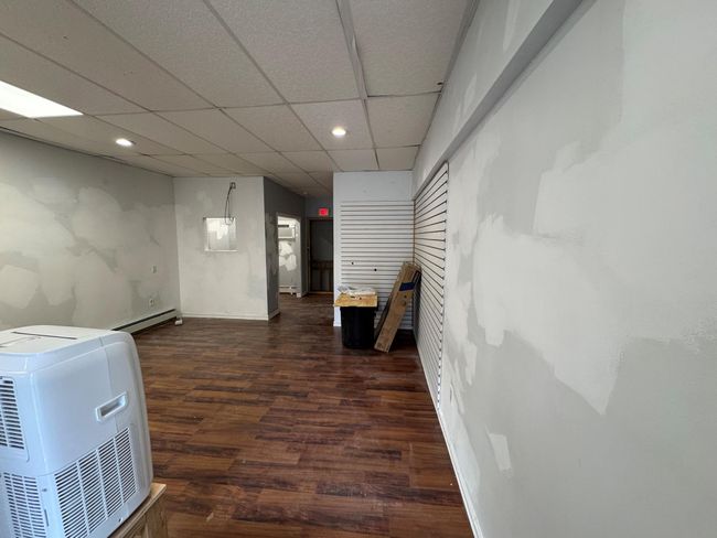 Hall with a drop ceiling, dark hardwood / wood-style floors, and baseboard heating | Image 8