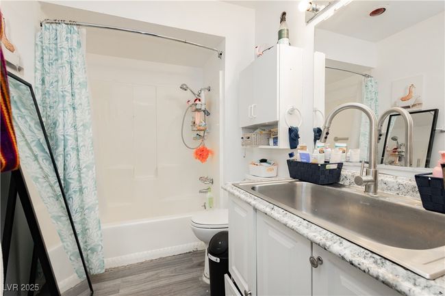 Bathroom with vanity, shower / bath combo with shower curtain, and wood finished floors | Image 12