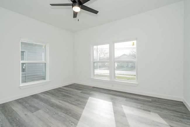 Empty room with wood finished floors, a ceiling fan, and baseboards | Image 13
