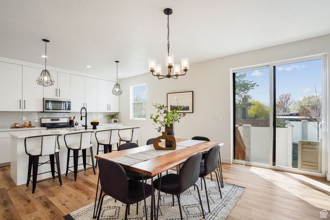 Dining area with light wood-style flooring, recessed lighting, and a chandelier | Image 8