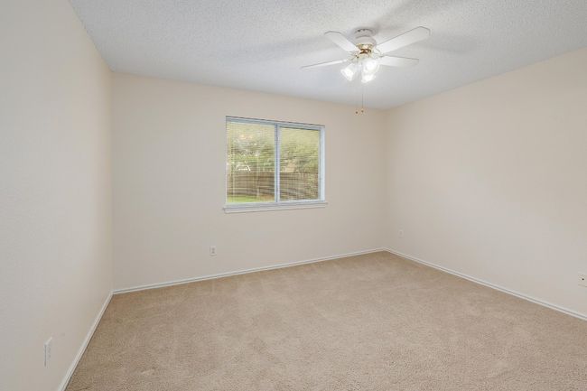Spare room featuring light carpet, a ceiling fan, a textured ceiling, and baseboards | Image 14