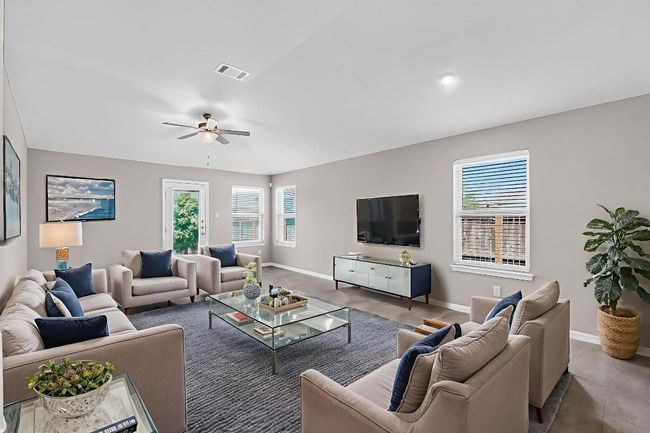 Living area featuring healthy amount of natural light, a ceiling fan, and tile patterned flooring | Image 6