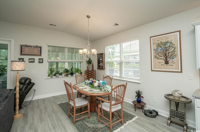 Dining space featuring a chandelier, light wood-style floors, baseboards, and lofted ceiling | Image 24