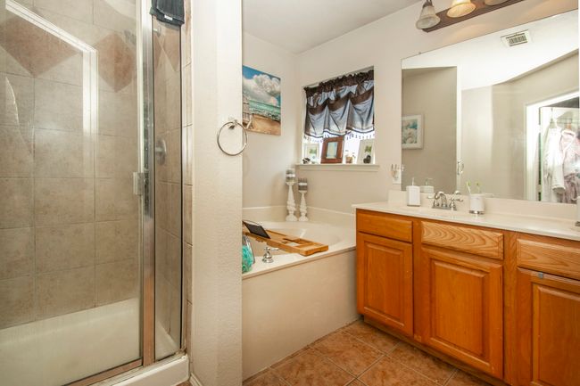 Bathroom with vanity, a shower stall, a bath, and tile patterned floors | Image 18
