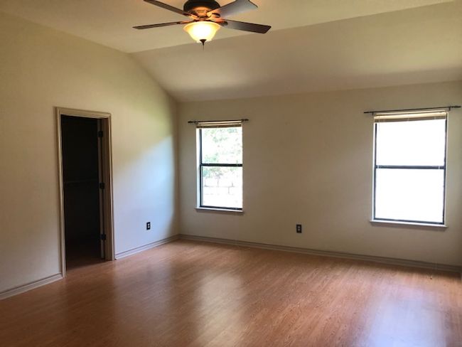 Unfurnished room featuring light wood-style floors, a ceiling fan, lofted ceiling, and baseboards | Image 6