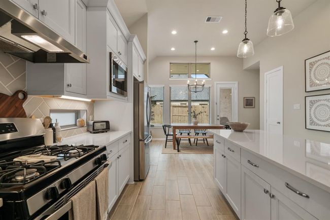 Gas range and wood tile flooring throughout. | Image 11