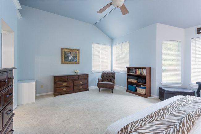 Bedroom with vaulted ceiling, light carpet, multiple windows, and a ceiling fan | Image 14