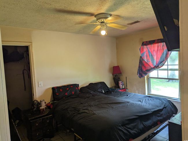 Bedroom with tile patterned floors, a textured ceiling, and ceiling fan | Image 7