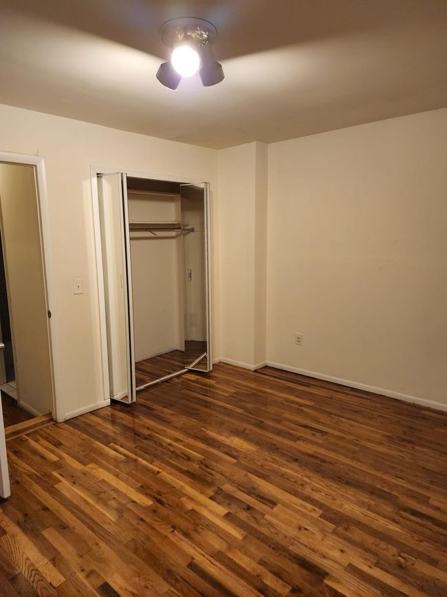 bedroom featuring dark wood-style floors, a closet, and baseboards | Image 7