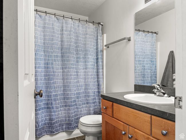 Bathroom featuring vanity, a textured ceiling, toilet, and walk in shower | Image 17
